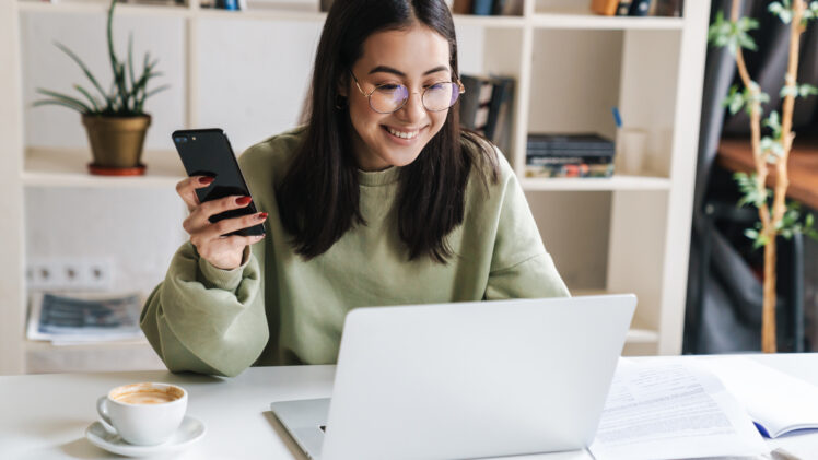 student smiling and looking at laptop computer